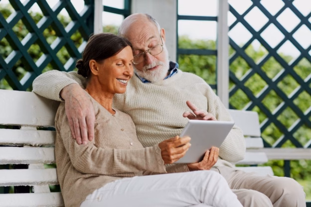 para uśmiechniętych seniorów korzysta z tableta
