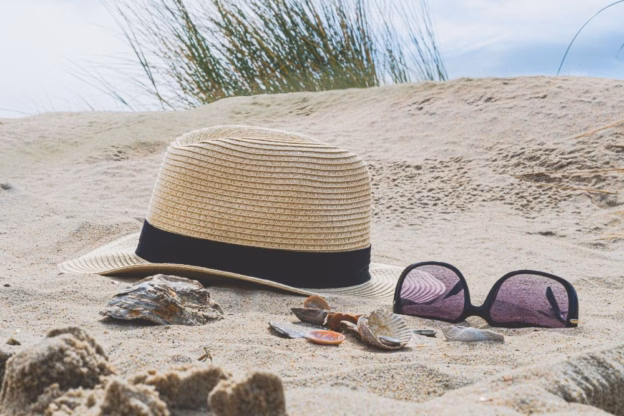 kapelusz słomkowy i okulary słoneczne na plaży