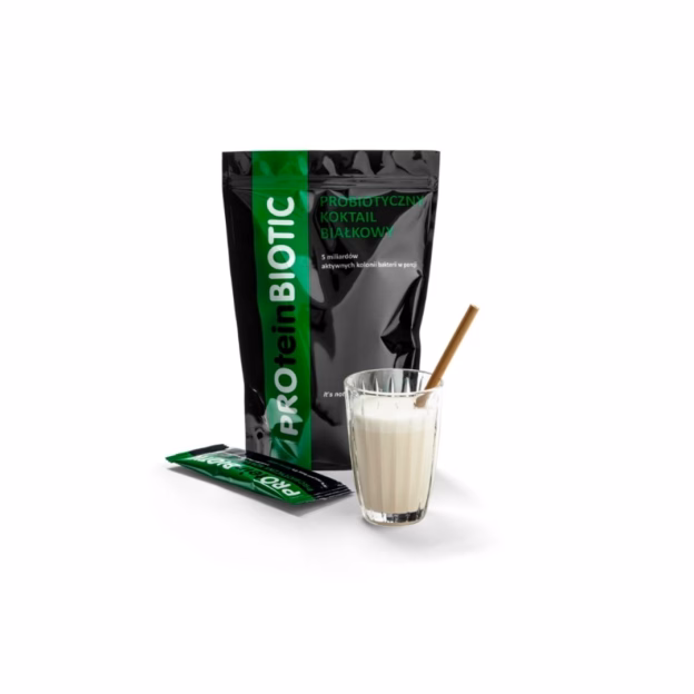 Opakowanie produktu PROteinBIOTIC, obok szklanka z białym koktajlem i słomką, a także mała, pojedyncza saszetka produktu