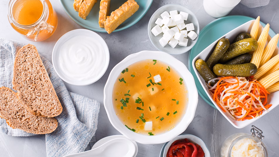 Różnorodne produkty fermentowane i probiotyczne ułożone na stole.