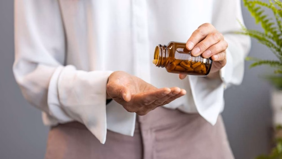 Kobieta trzymająca butelkę z probiotykiem