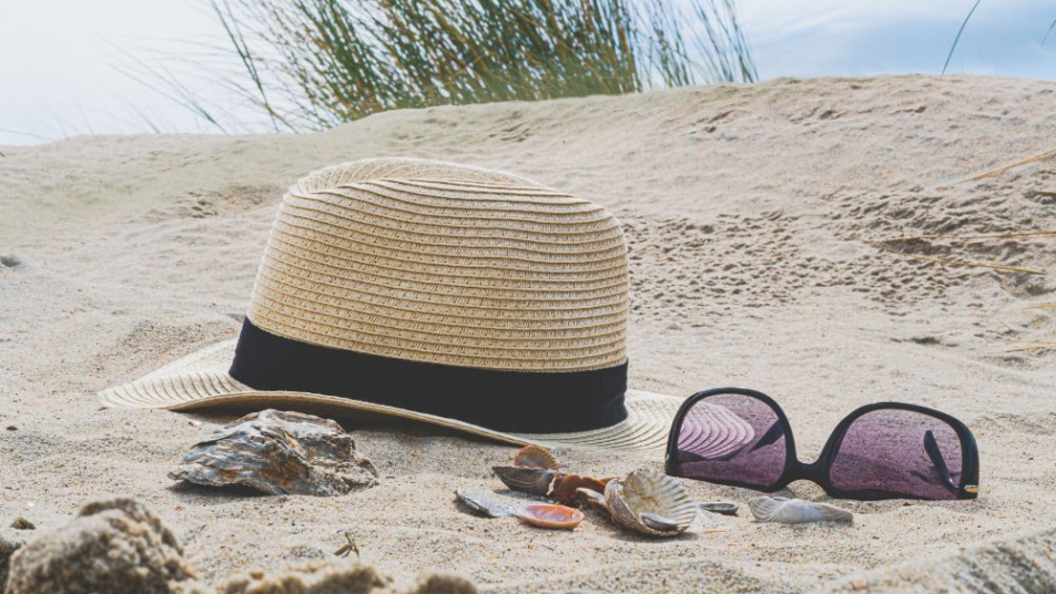 kapelusz słomkowy i okulary słoneczne na plaży