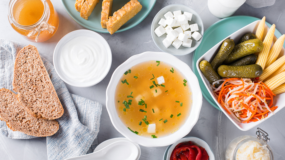 Różnorodne produkty fermentowane i probiotyczne ułożone na stole.