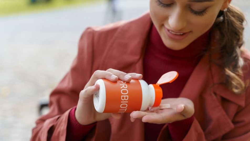 Kobieta trzymająca butelkę z probiotykiem.