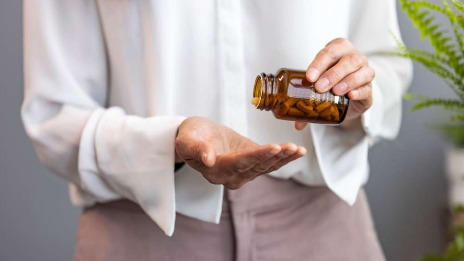 Kobieta trzymająca butelkę z probiotykiem